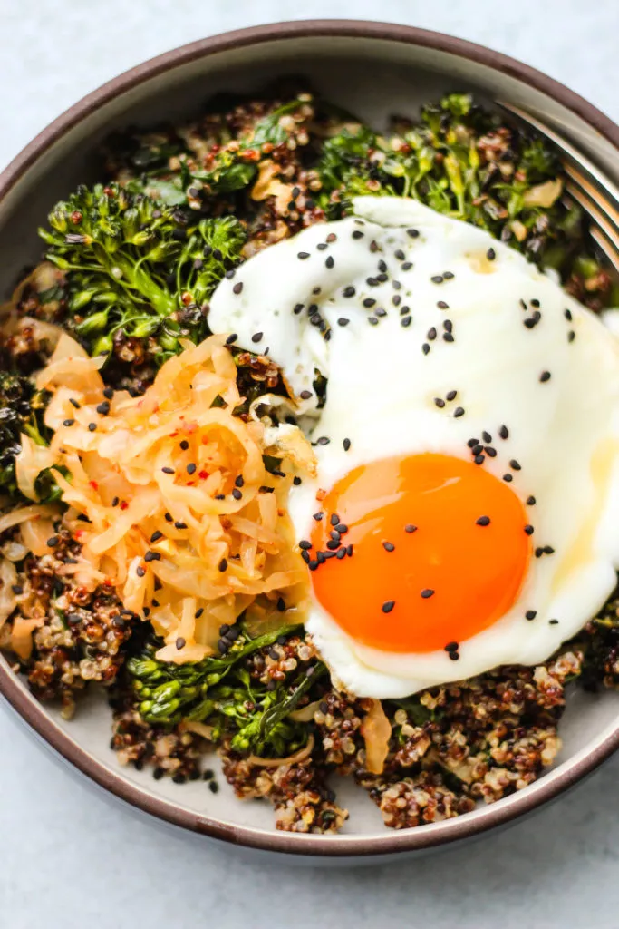 quinoa, kimchi, broccolini, and egg in bowl
