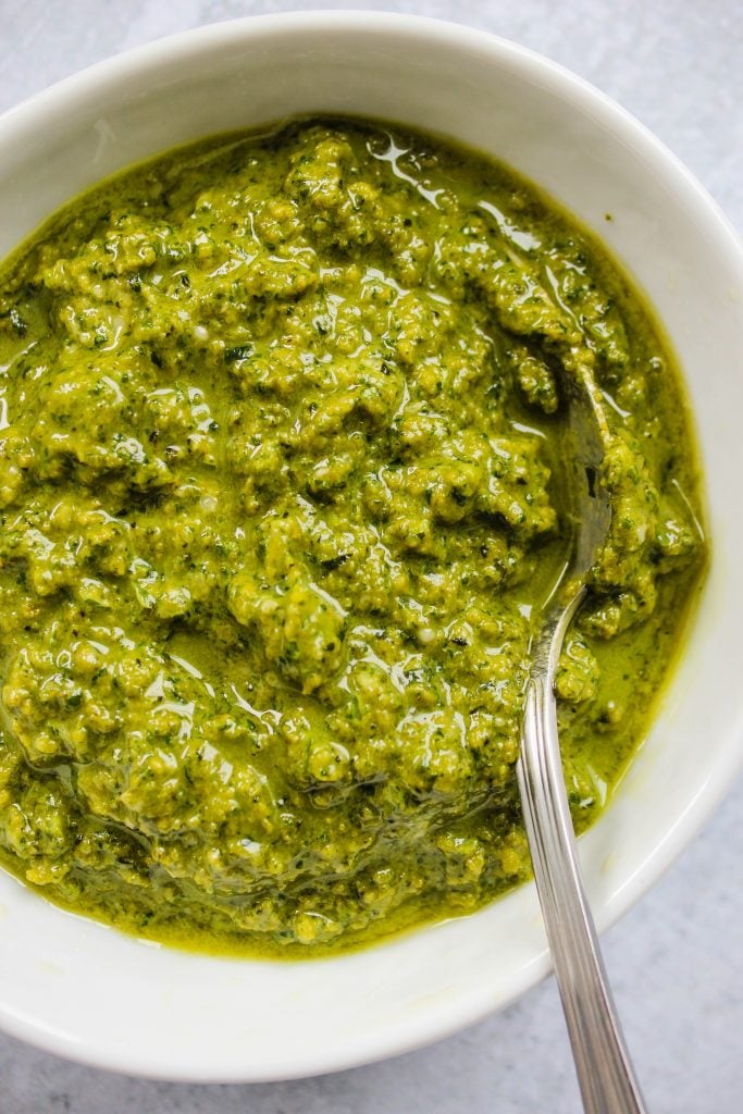 white bowl with homemade pesto and spoon
