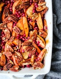 apple, pear, pomegranate and pecan fruit bake in white baking dish