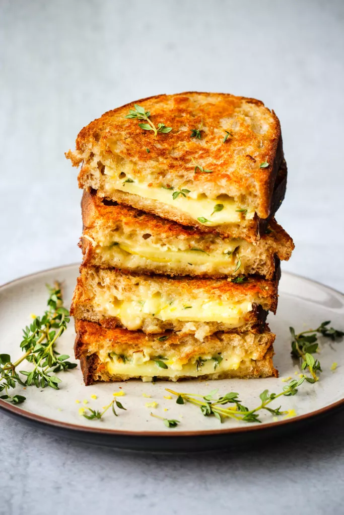 gourmet grilled cheese sandwich stacked on plate
