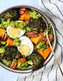 pesto quinoa bowl with sweet potatoes, broccoli, hard boiled egg, pecans
