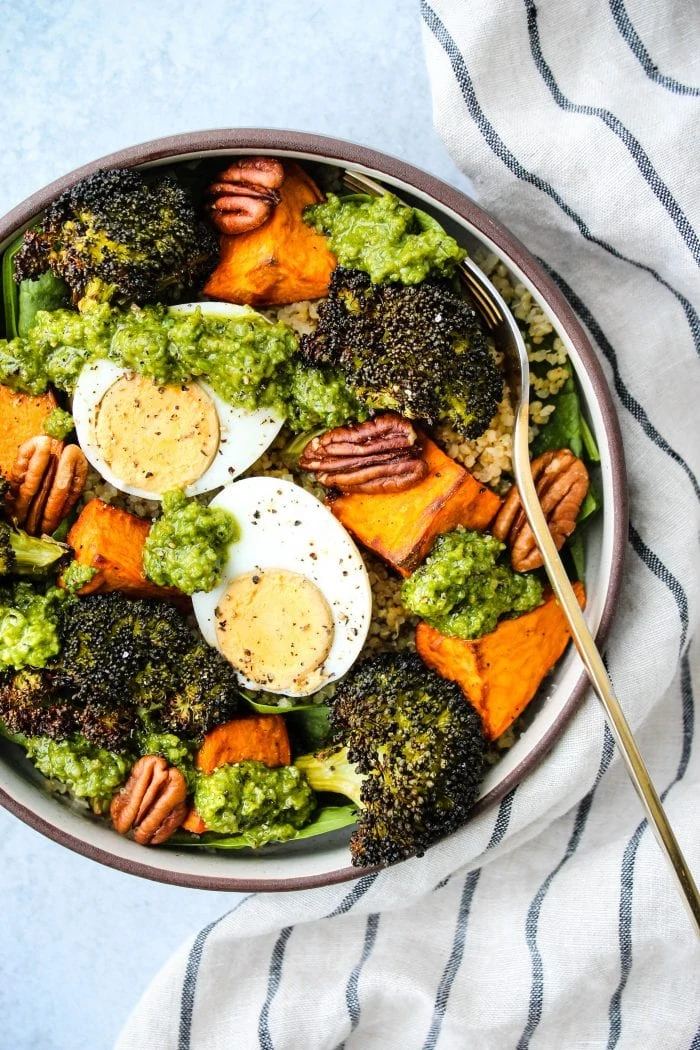 pesto quinoa bowl with sweet potatoes, broccoli, hard boiled egg, pecans