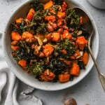Overhead photo of roasted butternut squash and kale in a white bowl.