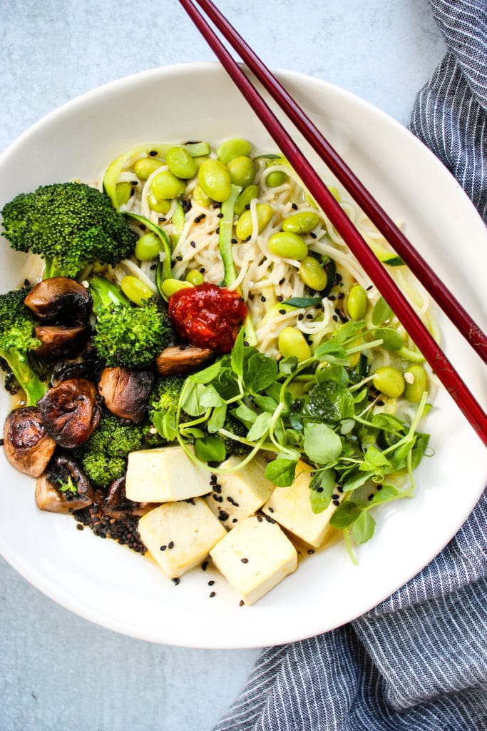 homemade miso ramen noodle soup with broccoli, mushrooms, tofu, and microgreens in white bowl 