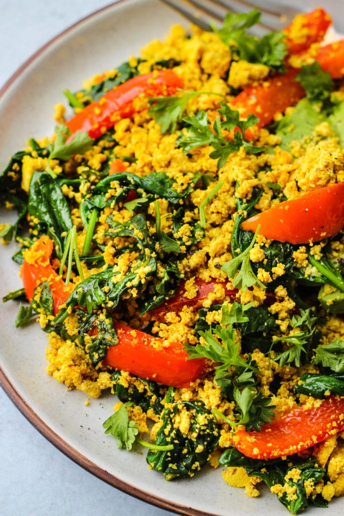 curry tofu scramble with red bell peppers and spinach on a plate