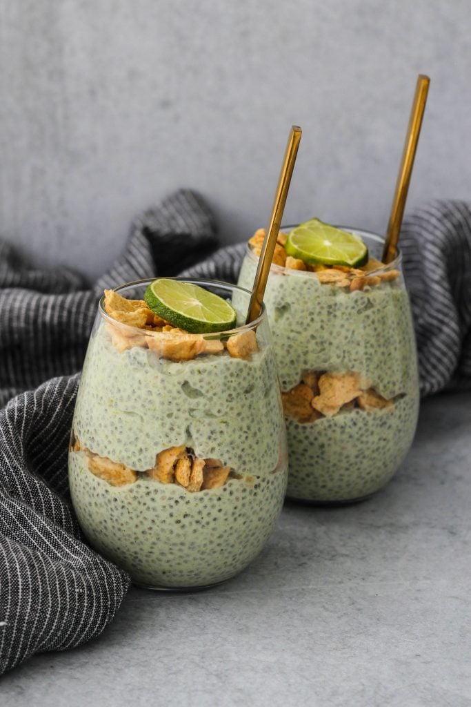 two glass jars with key lime pie chia pudding parfaits and blue towel