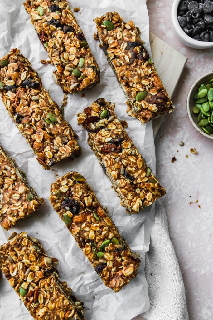 Closeup overhead photo of healthy homemade no-bake granola bars on white piece of parchment paper.