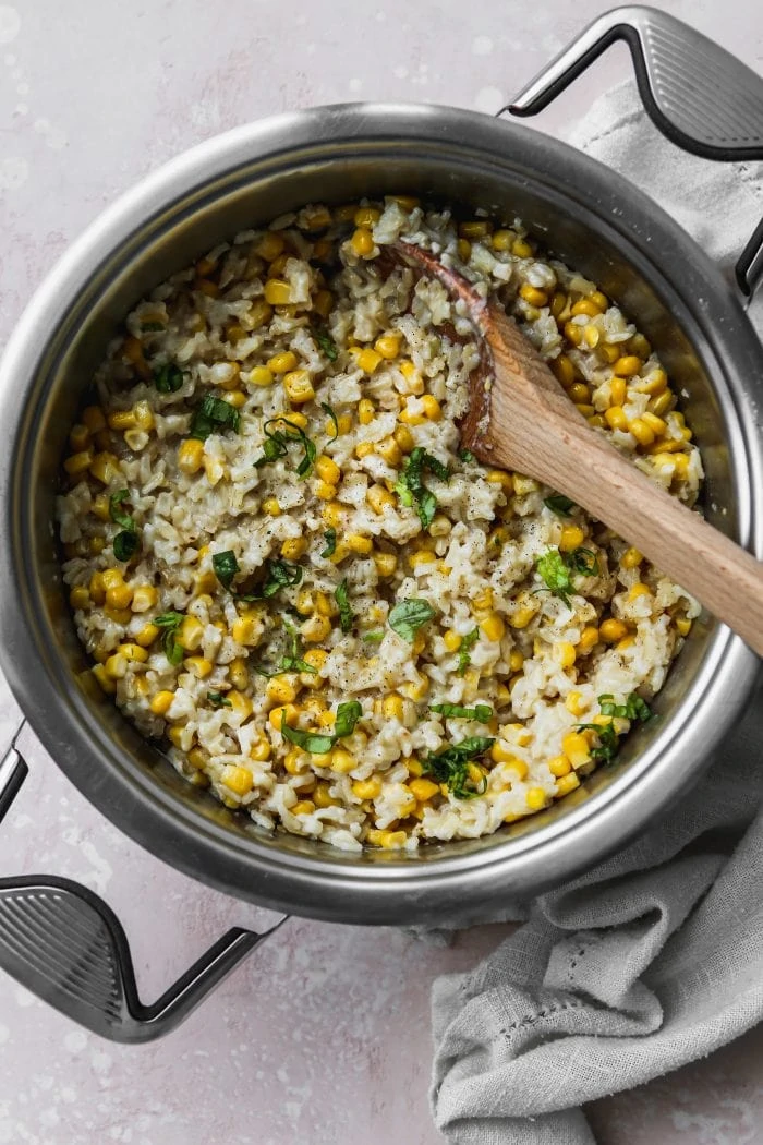 Overhead photo of a large cooking pot filled with corn and coconut rice.