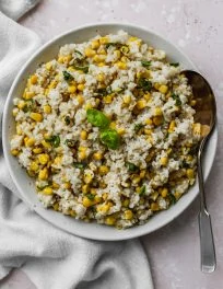 Overhead photo of cooked coconut corn rice in a large white bowl.