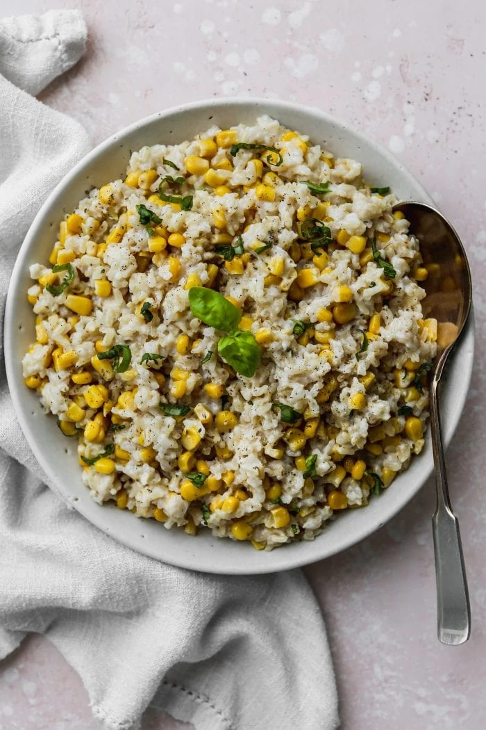 Overhead photo of cooked coconut corn rice in a large white bowl.