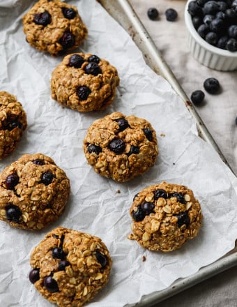 Lemon blueberry oatmeal cookies on a parchment-lined baking sheet.