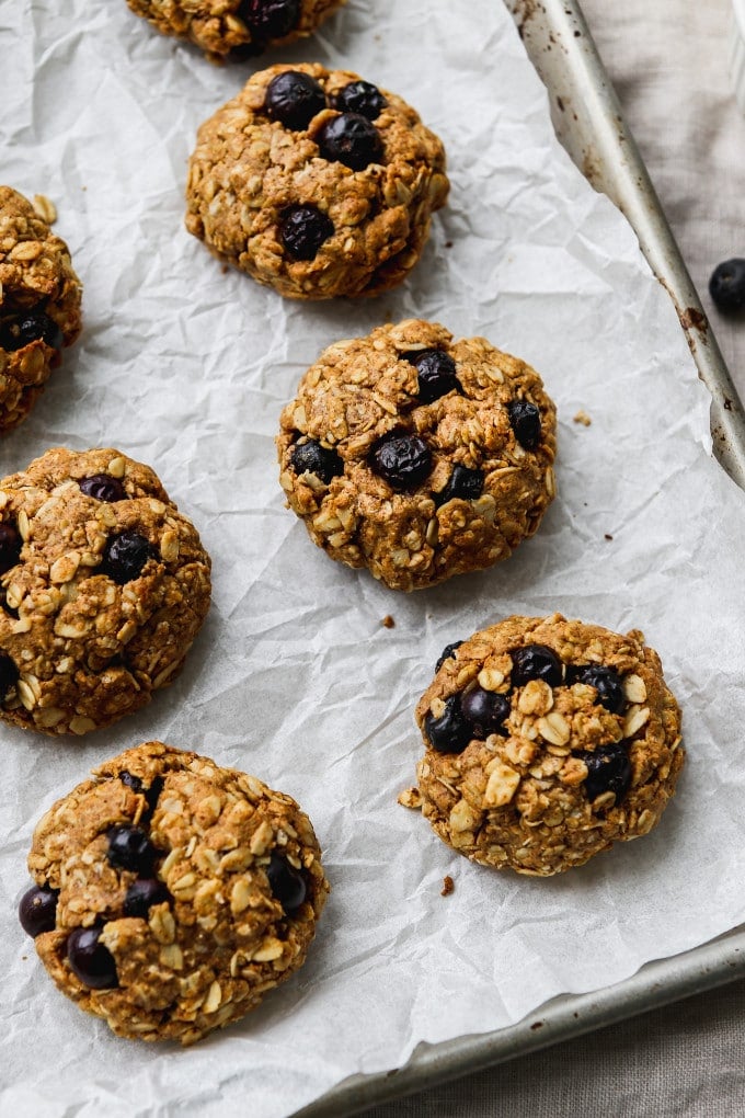 Lemon blueberry oatmeal cookies on a parchment-lined baking sheet.