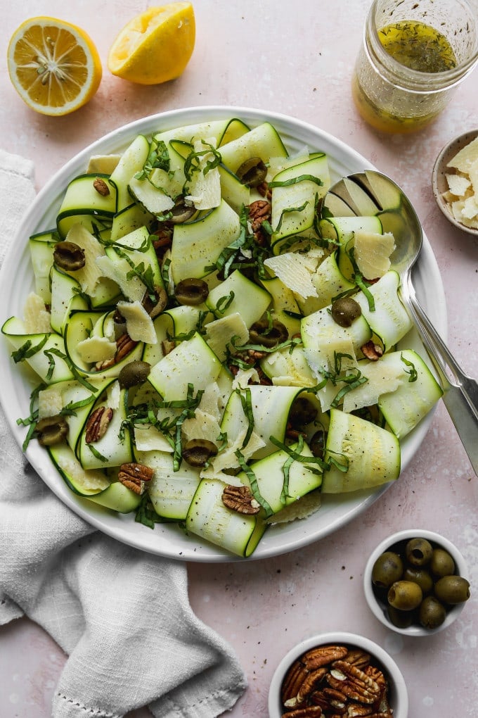 Overhead photo of a shaved zucchini salad on a white plate.