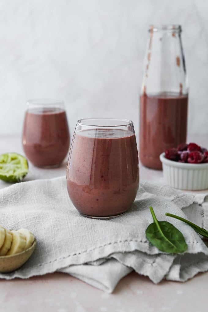 Straight on photo of a raspberry banana smoothie in glass cups.