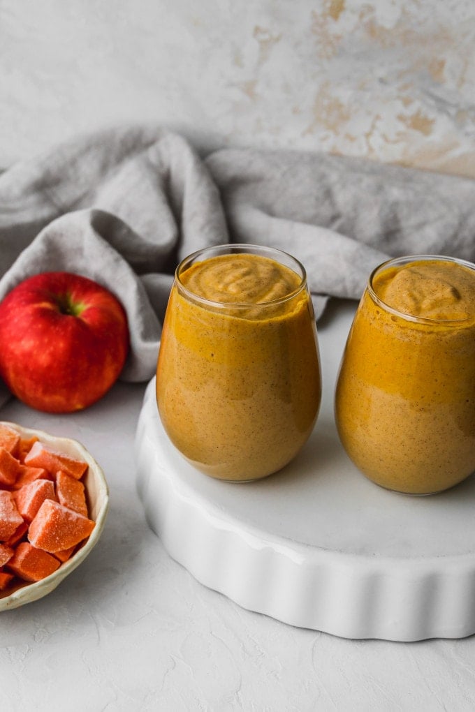 Overhead photo of two small glasses filled with a sweet potato and apple smoothie.