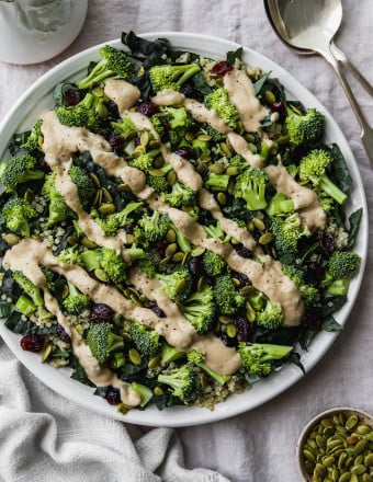 Overhead photo of a broccoli and kale salad with a tahini dressing drizzled overtop.