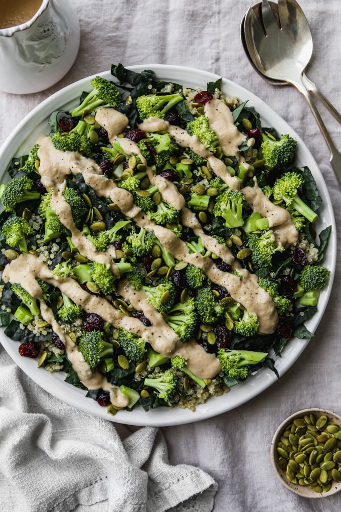 Overhead photo of a broccoli and kale salad with a tahini dressing drizzled overtop.