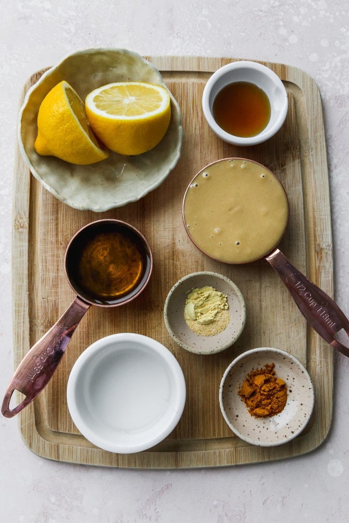 Overhead photo of small bowls of ingredients on top of a wood cutting board.