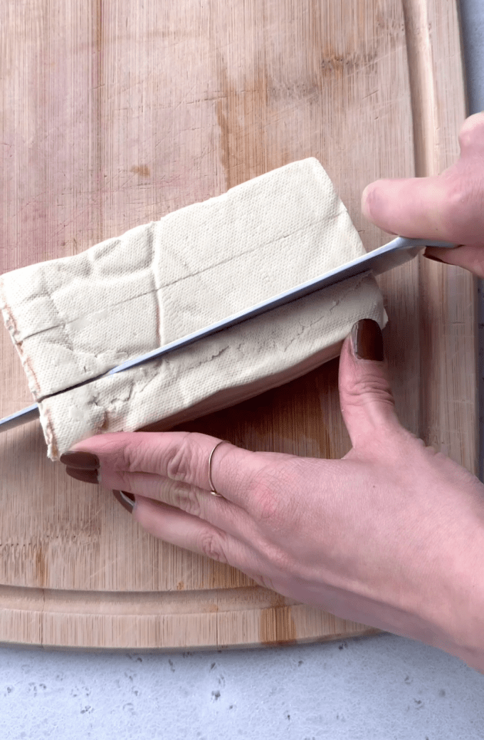 Cutting a block of tofu into thirds.