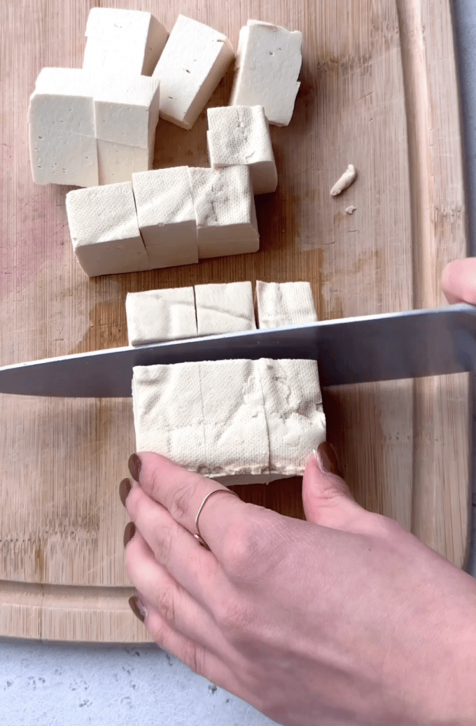 Cutting a block of tofu into cubes.