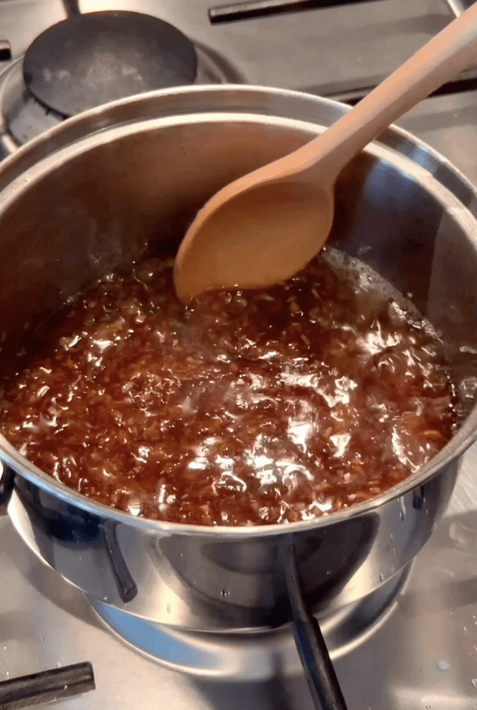 Mixing honey, garlic, soy, and sesame sauce in a small pot.