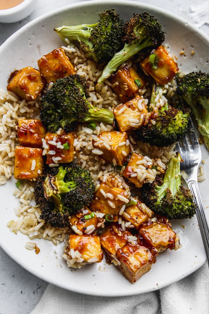 Closeup photo of bowl of honey garlic tofu with brown rice and broccoli mixed together.