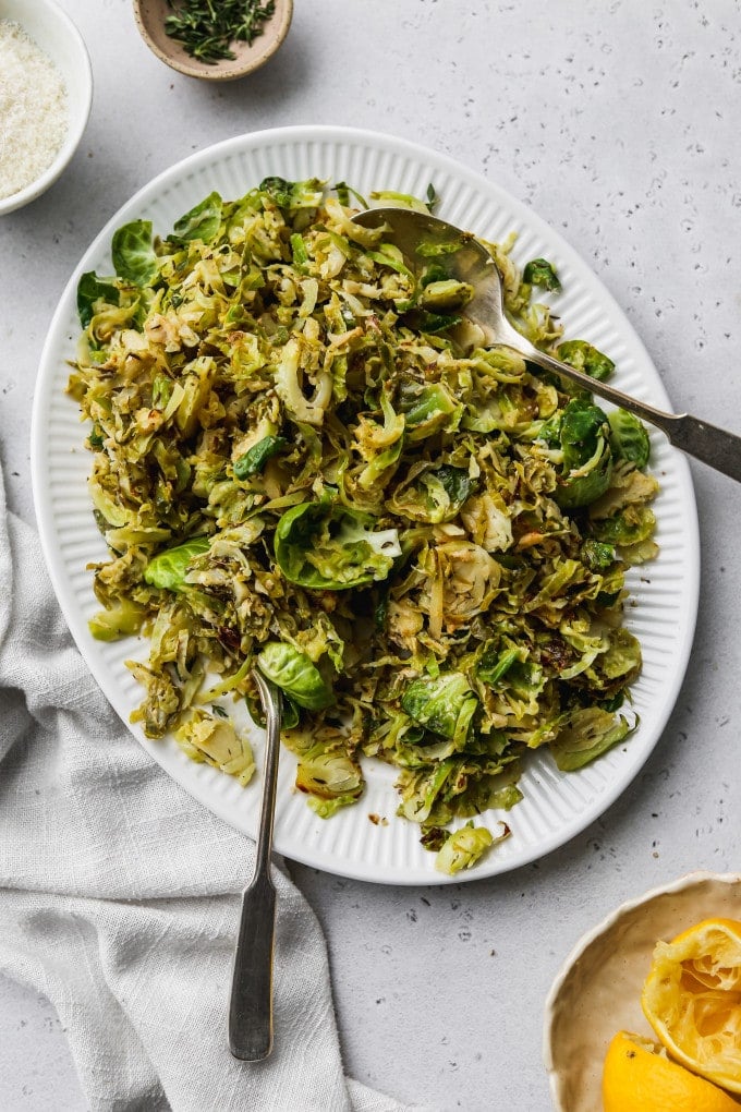 Overhead photo of sautéed shredded brussels sprouts on a white serving plate.