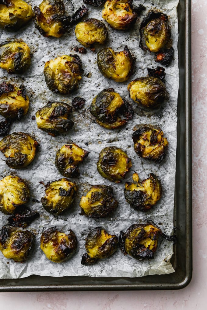 Overhead photo of smashed and roasted brussels sprouts on a baking sheet.