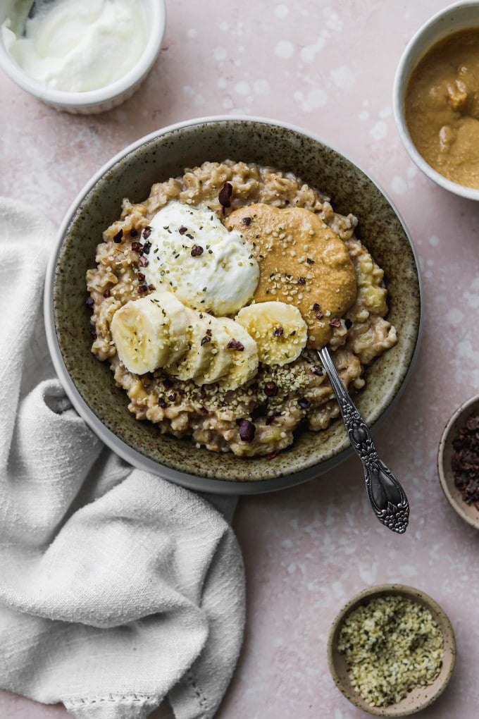 Overhead photo of a bowl of oatmeal porridge topped with banana and tahini.