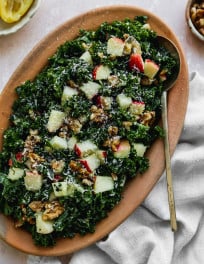 Overhead photo of a kale apple salad with walnuts and parmesan in a serving dish.
