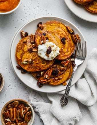 Overhead photo of 3 butternut squash pancakes on a white plate.