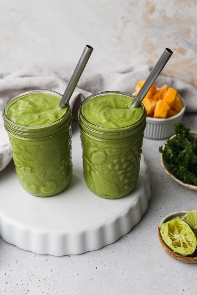 Photo of two jars of kale mango green smoothie.