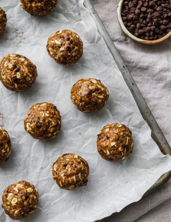 Overhead photo of almond butter energy balls on a parchment-lined baking sheet.