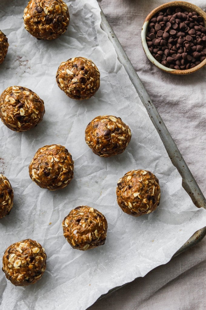 Overhead photo of almond butter energy balls on a parchment-lined baking sheet.