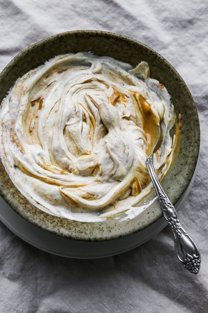 Overhead photo of a bowl of greek yogurt, peanut butter, cinnamon, and honey stirred together.
