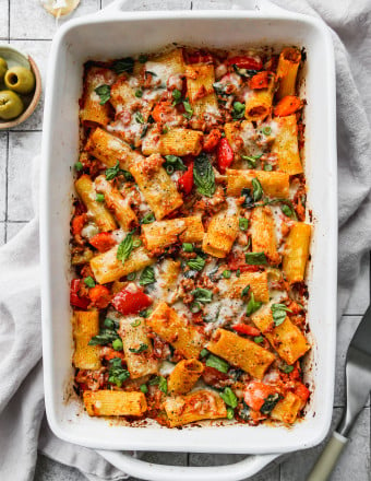 Tuna tomato pasta bake with vegetables in a white baking dish.