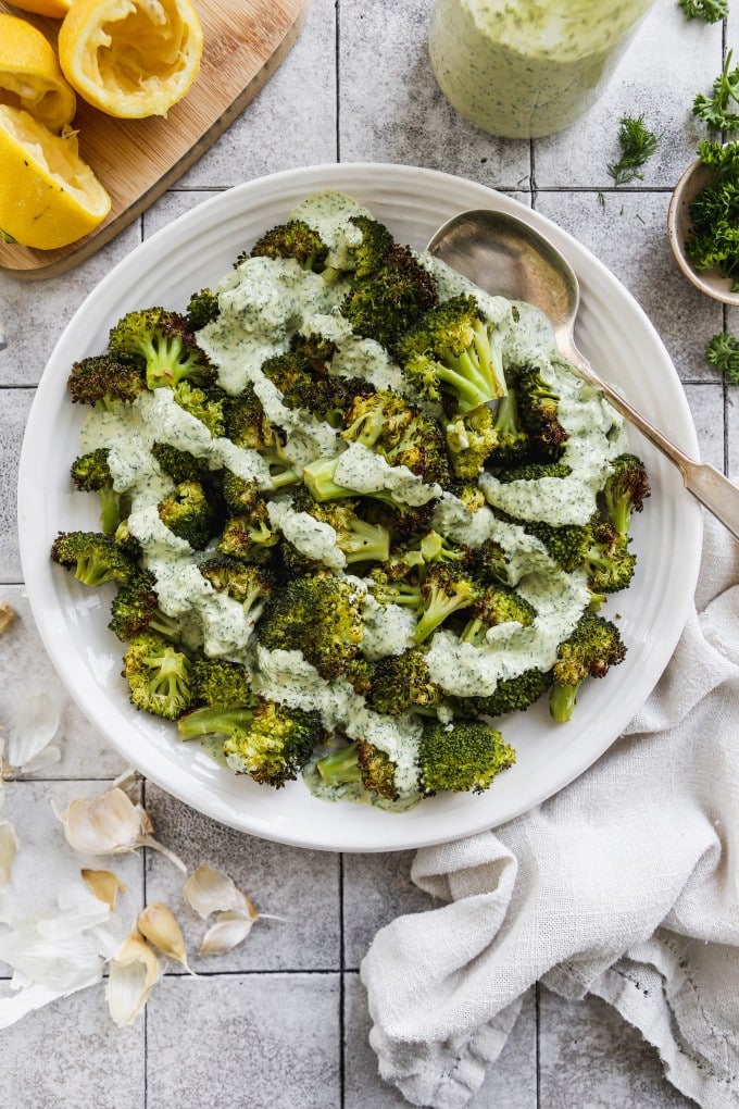 Roasted broccoli topped with a drizzle of lemon herb tahini sauce.