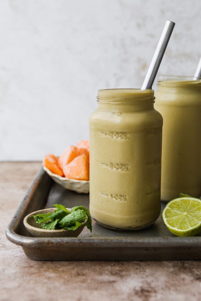 Cantaloupe melon smoothie in two glass jars.