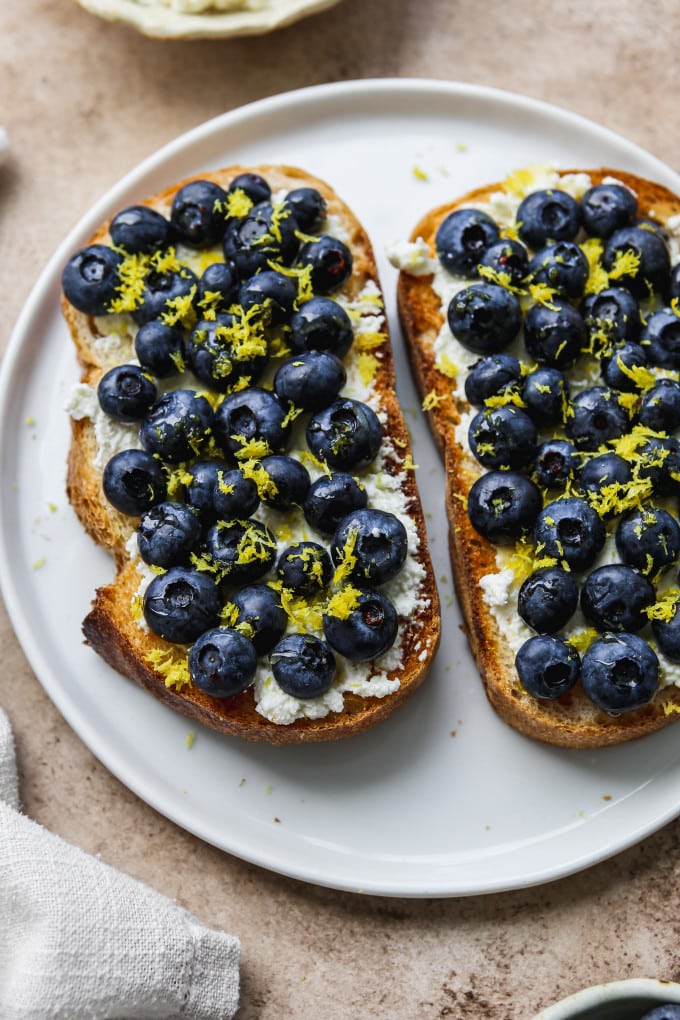 Blueberry ricotta toast on a white plate.