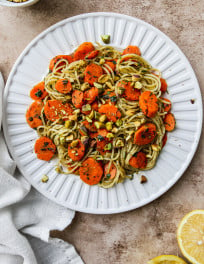 Carrot pasta on a white plate.