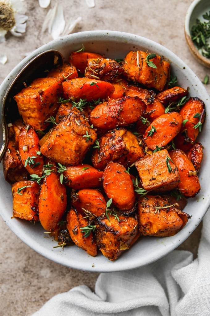 Roasted sweet potatoes and carrots in a serving bowl.