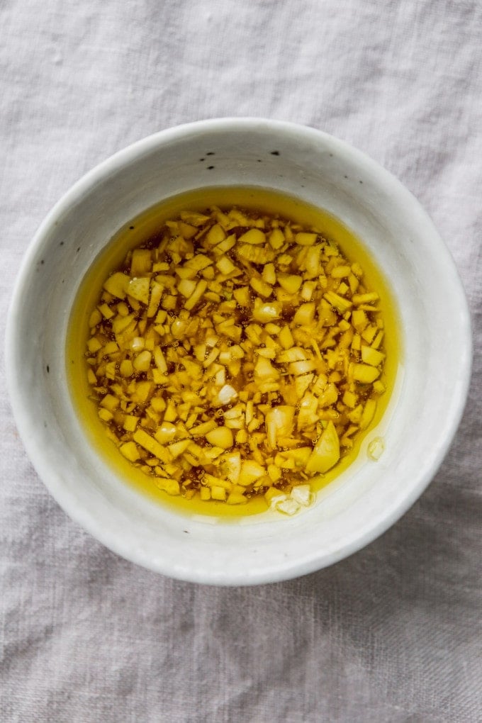 Honey, olive oil, and minced garlic mixed in a bowl.