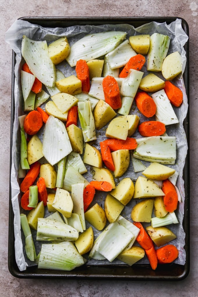Chopped vegetables spread out on a sheet pan.