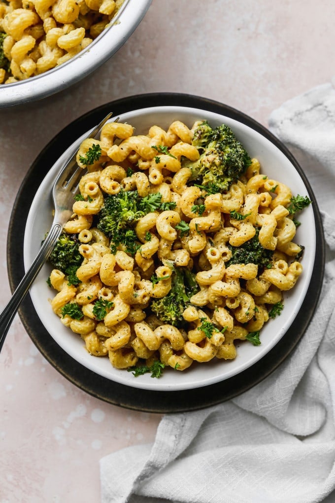 A serving of tahini pasta with broccoli in a bowl.