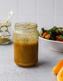 Nutritional yeast salad dressing with lemon and tamari in a small glass jar.