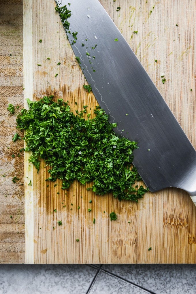Roughly chopped parsley on a cutting board.