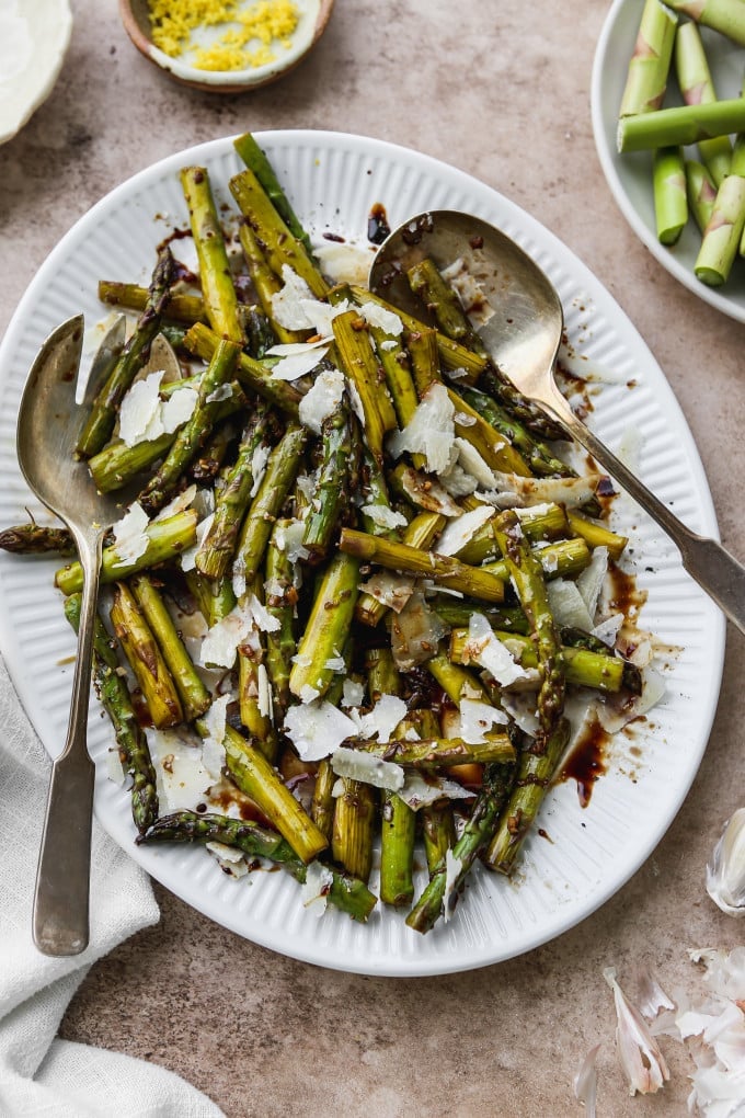 Pan fried asparagus with balsamic and parmesan on a serving platter.