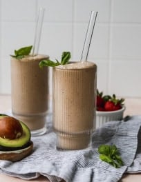 Strawberry avocado smoothie in 2 tall glasses.