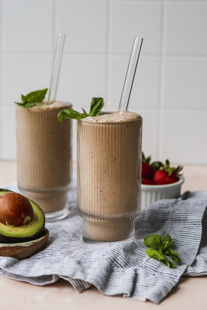 Strawberry avocado smoothie in 2 tall glasses.