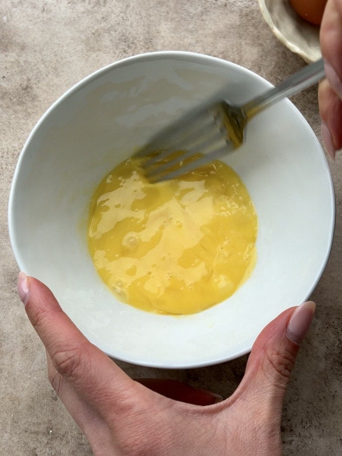Two whisked eggs in a bowl.